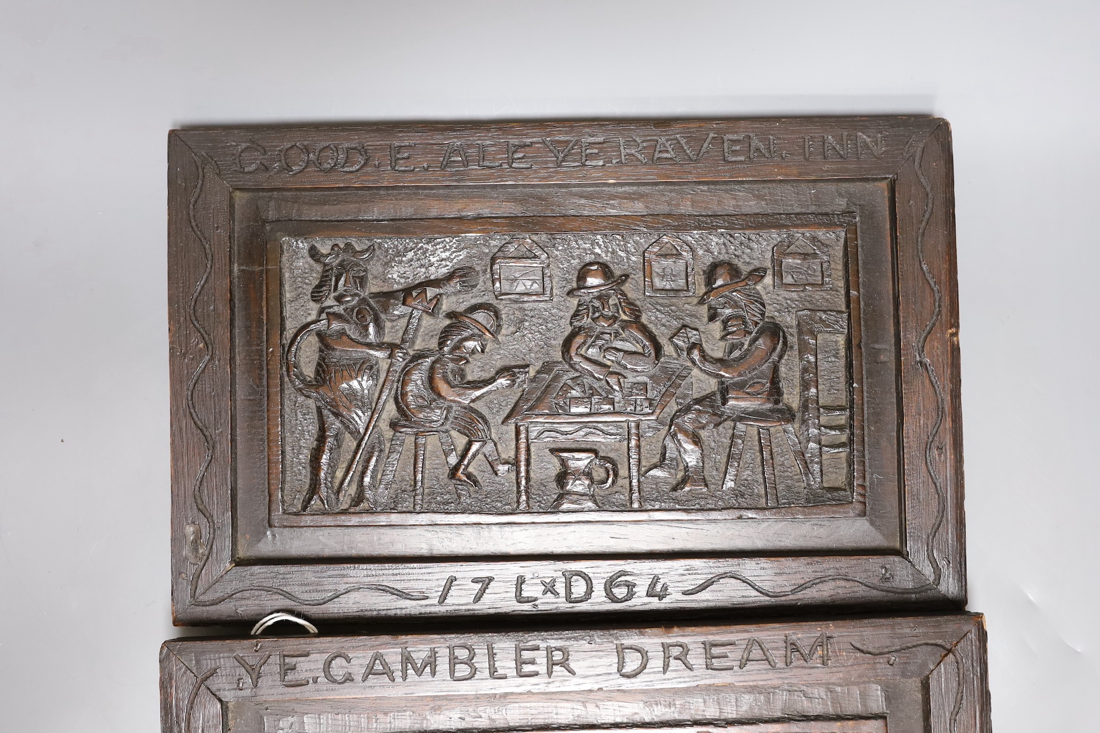 A pair of folk art oak panels, later frames:, “Good ale ye raven inn” and “Ye gambler dream”, 35.5 cms wide x 23 cms